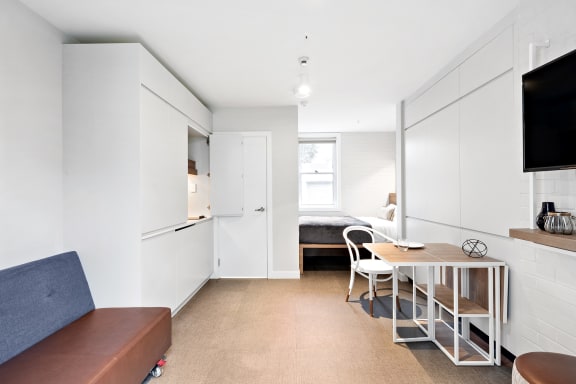 a living room and dining room with a table and chairs