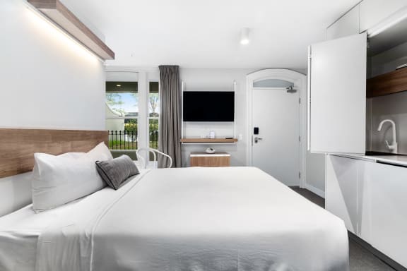 a bedroom with a large white bed and a television