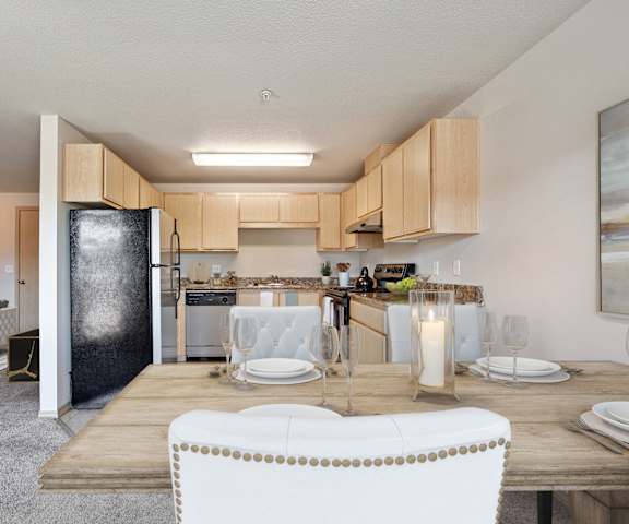 A modern kitchen with a dining table set for two.