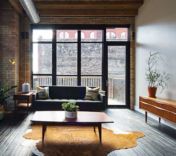 A living room with a couch, a table, and a window.