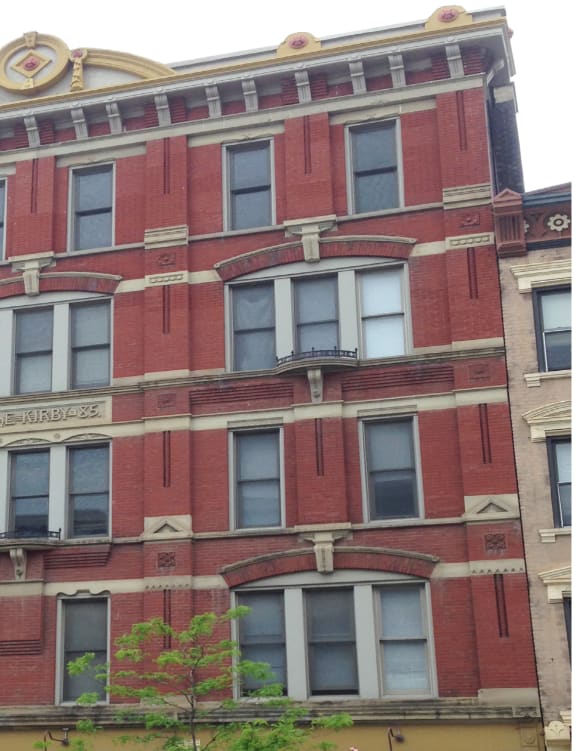 a building on the corner of a street with cars parked in front of it