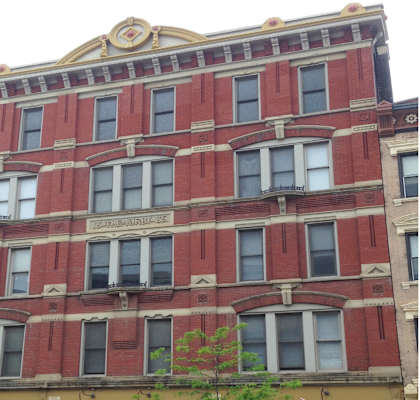 the front of a red brick building with many windows