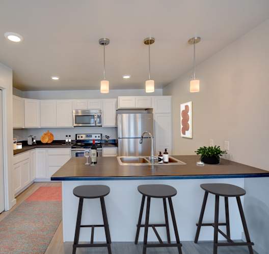 A kitchen with a bar area and a sink.