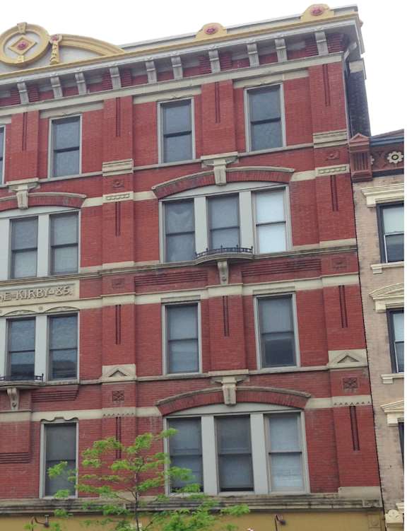 a building on the corner of a street with cars parked in front of it