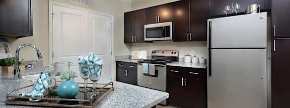 A kitchen with a granite countertop and stainless steel appliances.