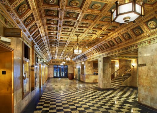 the lobby of a building with a checkered floor and an ornate ceiling
