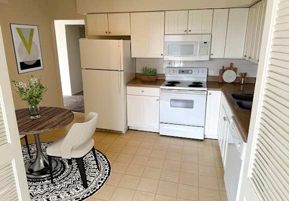 a kitchen with white appliances and a dining room table