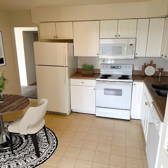a kitchen with white appliances and a dining room table