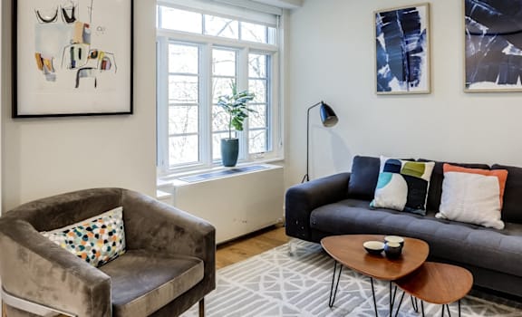A living room with a grey couch, a brown armchair, and a coffee table.