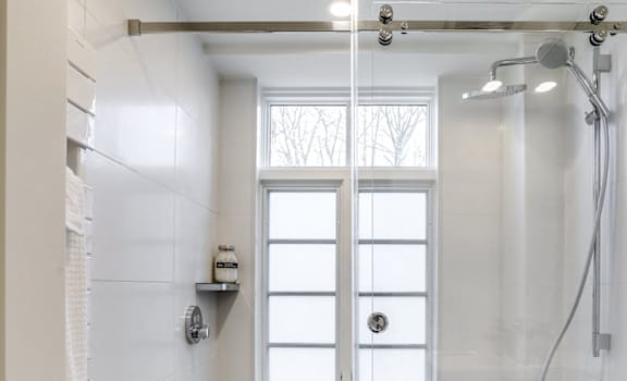A white bathroom with a glass shower door.