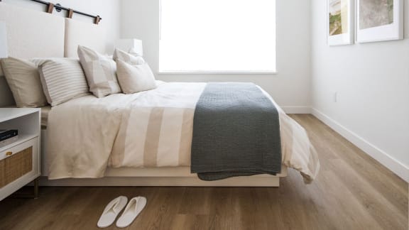 a bedroom with a bed with white sheets and pillows