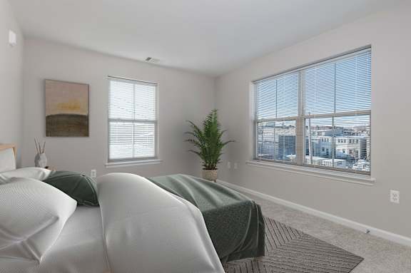 A bedroom with two beds and a large window.