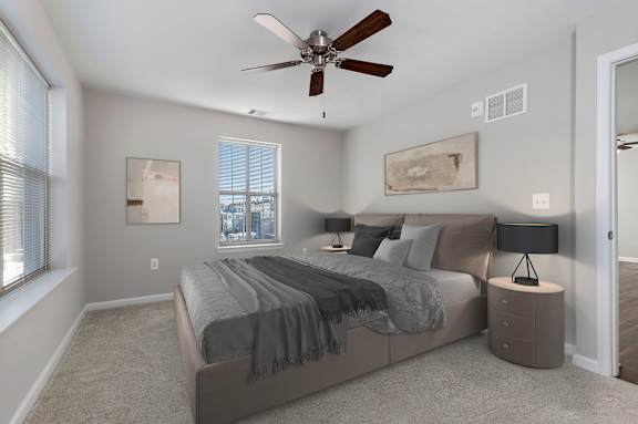 A bedroom with a bed, nightstands, and a ceiling fan.