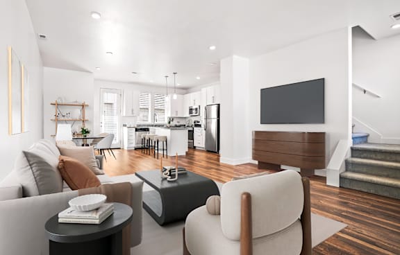 A modern living room with a glass table and chairs, a sofa, and a TV.