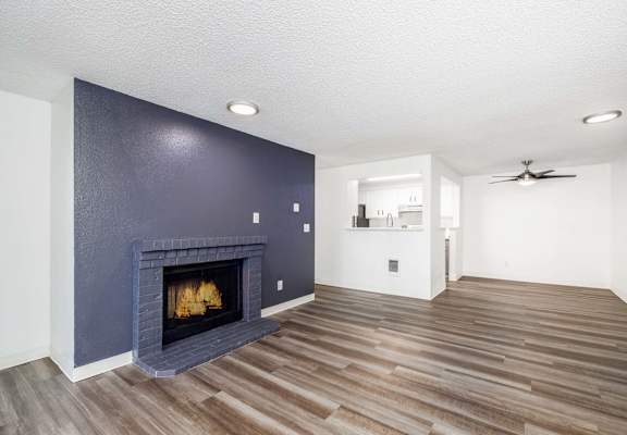 A room with a fireplace and wood flooring.