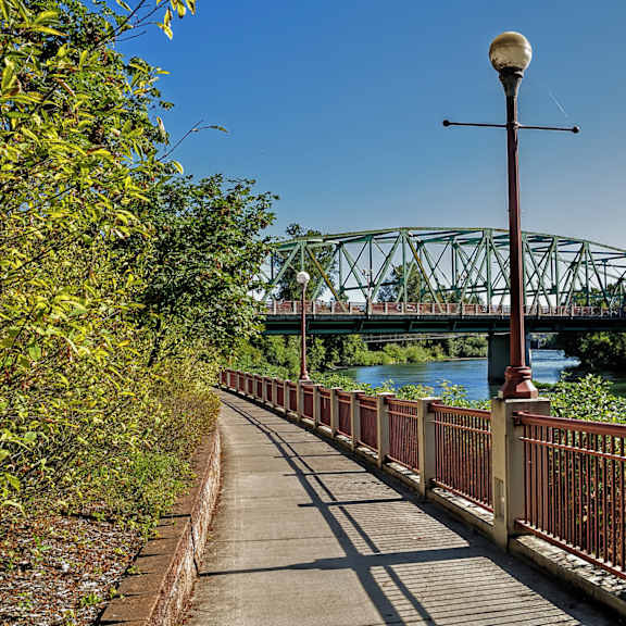 A bridge over a river with a lamp post on the sidewalk.