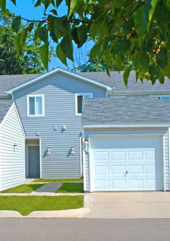 a blue house with two garage doors and a sidewalk