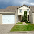 a house with two garage doors and a lawn