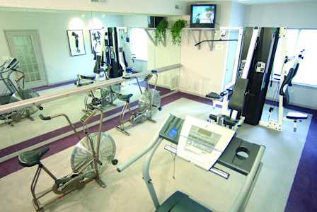 a room filled with weights and cardio equipment in a gym