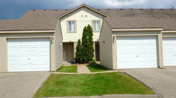 a house with two garage doors and a lawn