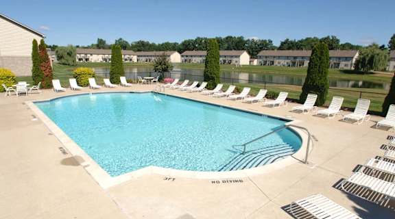 an aerial view of a swimming pool with lounge chairs around it