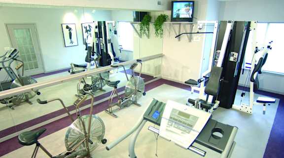a room filled with weights and cardio equipment in a gym