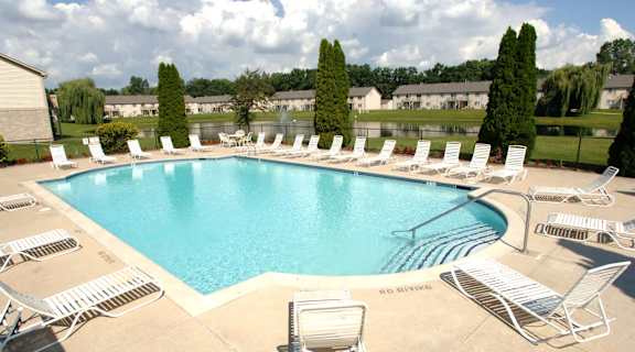 a swimming pool with chairs and chairs around it