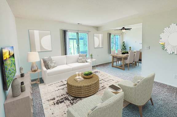 A living room with a white couch, a coffee table, and a large sunburst mirror on the wall.