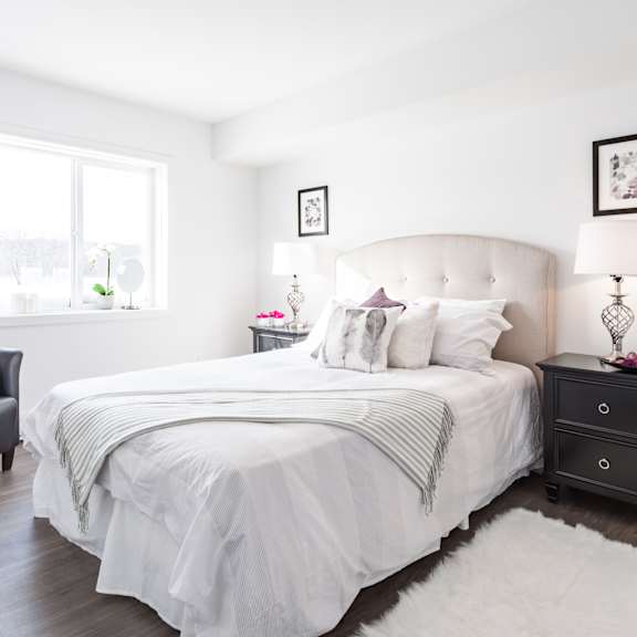 A bedroom with a large bed and a painting on the wall.