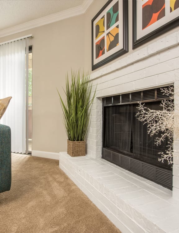 a living room with a fireplace and a green couch at Lodge of Overland Park Apartments, Overland Park , 66212
