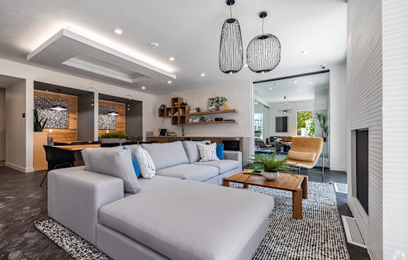 A modern living room with a glass table and chairs, a sofa, and a TV.