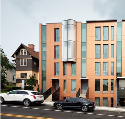 a new building on a city street with cars