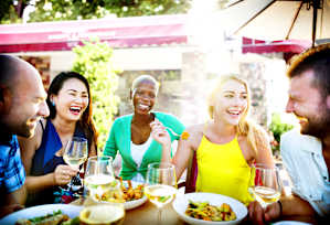 A group of people enjoying a meal together at an outdoor restaurant.
