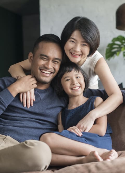 a family sitting on a couch in a living room at Brookwood at Sayville, Sayville