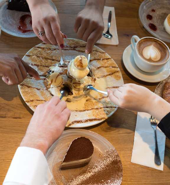 a group of people sitting around a table eating food