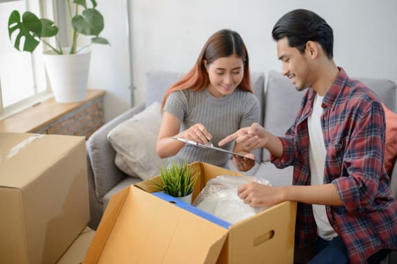 two people unpacking boxes in a living room