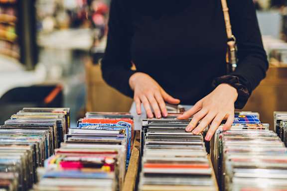 Person is browsing through a collection of CDs at AMP 30 Apartments, San Diego, California