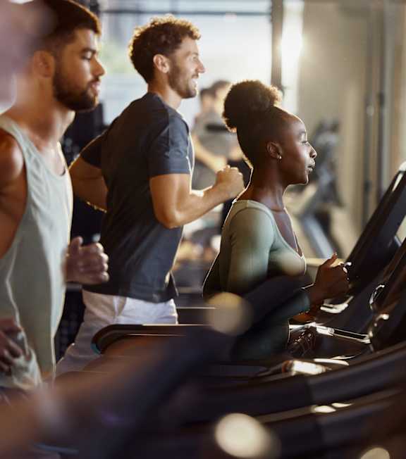 A group of people are exercising on treadmills in a gym.