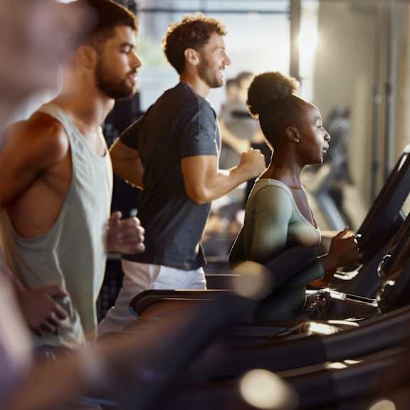 A group of people are exercising on treadmills in a gym.