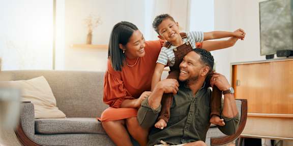 A family of three is having fun in their living room.