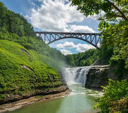 A bridge over a river with a waterfall underneath it.
