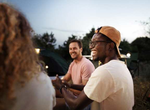 a group of people laughing and talking at an outdoor event
