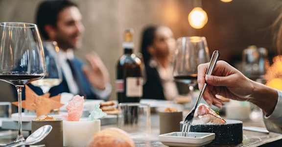 a person eating food at a restaurant table with wine glasses at Allure at Edinburgh, Virginia, 23322