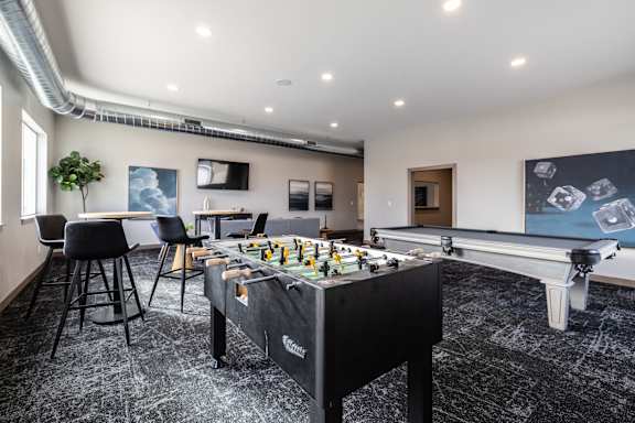 A foosball table is in the middle of a room with a black and white floor.