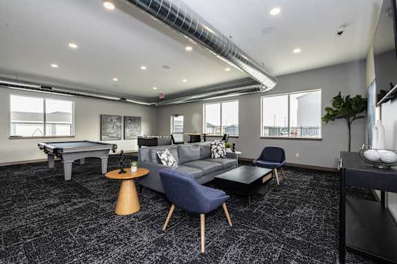 A living room with a pool table and a couch.