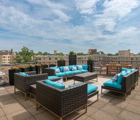 A patio with furniture and a view of buildings in the background.
