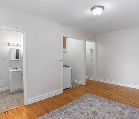 a living room with a door to a bathroom and a rug