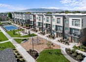 Thumbnail 1 of 9 - Apartment complex with a playground and a pool.