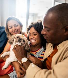 A family is sitting together with a dog.