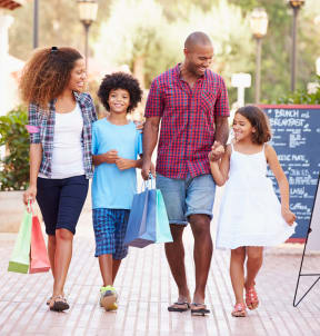 a family walking down the street with shopping bags